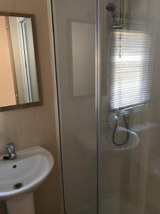 a bathroom with a glass shower and a sink at Summer Breeze in Aviemore