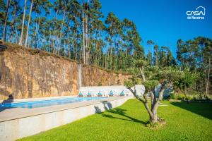 ein Pool vor einer Wand mit einem Baum in der Unterkunft Casa de Naceiros - Ponte de Lima in Viana do Castelo