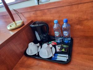 a tray with a tea kettle and two bottles of water at Falborek Noclegi in Brześć Kujawski