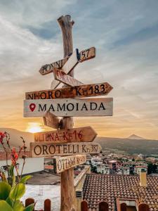 a street sign with arrows pointing in different directions at AbbaNive in Mamoiada