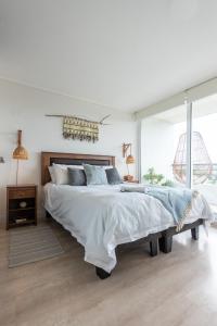 1 dormitorio con cama grande y ventana grande en Depto con Vista soñada y tinaja a pasos del centro en Puerto Varas