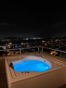a hot tub on the roof of a building at night at Class Hotel Bosphorus With Jacuzzi in Istanbul