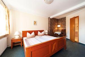 ein Schlafzimmer mit einem großen Holzbett in einem Zimmer in der Unterkunft Pension Villa Irene in Kurort Gohrisch