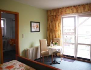 um quarto com uma mesa, uma cama e uma janela em Pension Villa Irene em Kurort Gohrisch