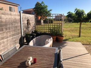 um urso de peluche sentado num deque ao lado de uma banheira em Maison Le Hamac du Golf em Fabrègues