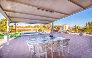 un patio al aire libre con una mesa y sillas blancas en Awesome Home In Molina De Segura With Kitchen, en Molina de Segura