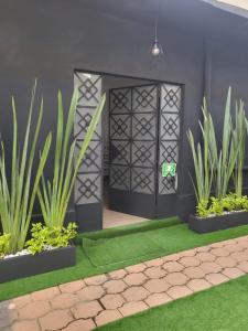 um pátio com uma porta preta e algumas plantas em Posada Paraíso em Cidade do México