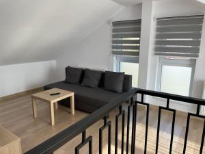 een woonkamer met een bank en een tafel bij Penthouse DH Apartments in Oradea