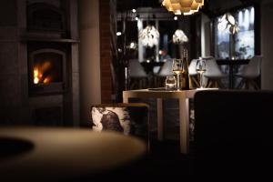 a table with wine glasses on it with a fireplace at Máttaráhkká Northern Light Lodge in Kiruna