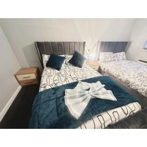 a bedroom with two beds with a robe on it at Cosy & Spacious Lodge Dartford in Kent