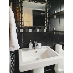 lavabo blanco en el baño con espejo en Cosy & Spacious Lodge Dartford, en Kent
