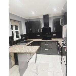 a kitchen with black cabinets and granite counter tops at Cosy & Spacious Lodge Dartford in Kent