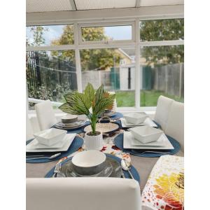 a dining room table with white chairs and a blue and white table at Cosy & Spacious Lodge Dartford in Kent