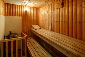 a wooden sauna with a wooden bench in it at Beautiful 'Mayfield' Villa with private pool! in Manchester