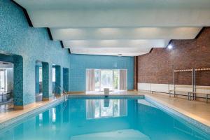 マンチェスターにあるBeautiful 'Mayfield' Villa with private pool!の青い壁とレンガの壁のスイミングプール