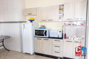 a kitchen with a refrigerator and a microwave at Cizah Hotel in Faxinal