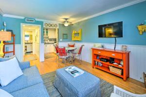 a living room with a couch and a tv and a table at Condo with Pool Access Walk to Shopping and Beach! in Naples