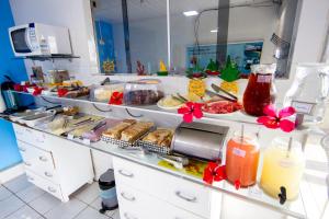 una linea di buffet con cibo e bevande in una cucina di Pousada São Silmares a Fernando de Noronha
