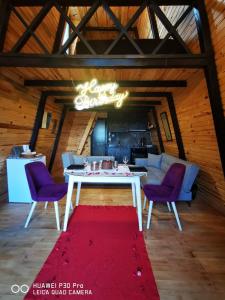 a dining room with a white table and purple chairs at İstanbul AirPort Bungalow in Arnavutköy