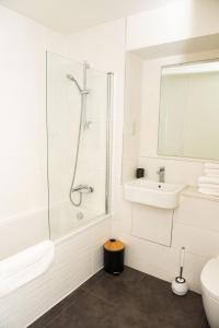 a white bathroom with a shower and a sink at Chi-Amore- 1 bed apartment-Bedford Town (Free Gym) in Bedford