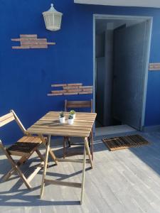 a wooden table and a chair and a blue wall at La Mongeta Màgica. in Castellón de la Plana