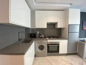 a kitchen with white cabinets and a washing machine at CORNICHE CASABLANCA - SUBLIME F2 NEUF in Casablanca