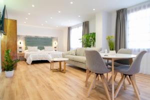 サン・クリストバル・デ・ラ・ラグーナにあるLaguna Home & Suitesのリビングルーム(ベッド1台、テーブル、椅子付)