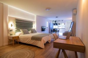 sypialnia z łóżkiem i biurkiem z laptopem w obiekcie Laguna Home & Suites w mieście La Laguna