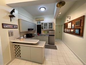cocina con armarios blancos y suelo de baldosa blanca en Sevenseas Marina Crescent, en Port Dickson