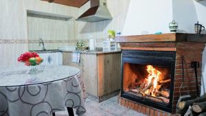 cocina con chimenea, mesa y fogones en Alojamiento Balcón Al Cerezuelo, en Cazorla