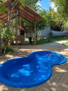a blue swimming pool in the middle of a yard at Safira Beach House in Pipa