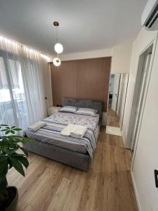 1 dormitorio con 1 cama grande y suelo de madera en Sphinx Apartment, en Durrës