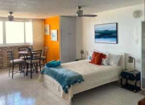 sypialnia z łóżkiem, stołem i krzesłami w obiekcie KASA Emmas Ocean View w mieście San Juan