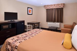 a hotel room with a bed and a flat screen tv at Americas Best Value Inn & Suites Madera in Madera