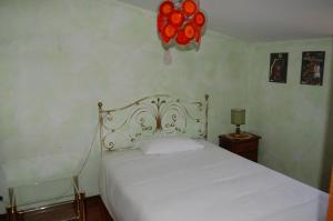 1 dormitorio con cama blanca y lámpara de araña roja en Villetta degli Ulivi, en Santa Rufina