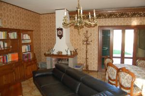 sala de estar con sofá y chimenea en Villetta degli Ulivi, en Santa Rufina