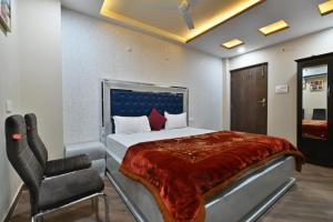 a bedroom with a bed and a chair at Hotel Lilac Doors in Patna