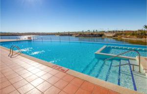 a large swimming pool with a large body of water at Cozy Apartment In Alhama De Murcia With Wifi in Alhama de Murcia