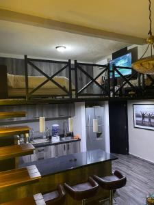 a room with a bunk bed and a bar with chairs at Independencia Dos 7 Hotel Boutique in Querétaro