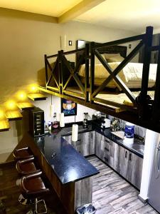 a kitchen area with a bar and chairs at Independencia Dos 7 Hotel Boutique in Querétaro