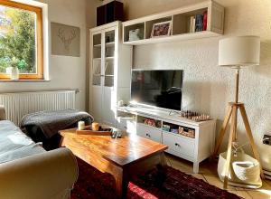 ein Wohnzimmer mit einem Sofa, einem TV und einem Tisch in der Unterkunft Ferienhaus mit Zirbitzblick in Mönchegg