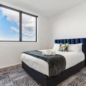 a bedroom with a large bed with a window at Roomie Apartment Hotel in Auckland