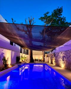 a swimming pool with a canopy over it at night at ACQUA IN BOCCA in Mérida
