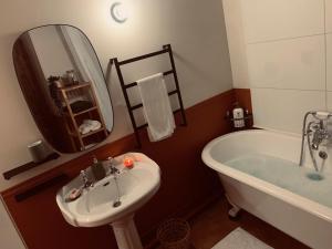 een badkamer met een wastafel, een bad en een spiegel bij Logement, plein centre du village de Verzy in Verzy