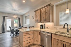 a kitchen with wooden cabinets and a dining room at Gorgeous Loveland Townhome Less Than 1 Mi to Downtown in Loveland