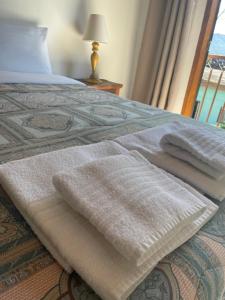 a bed with two towels on it with a window at Sobrado Torre in Tiradentes