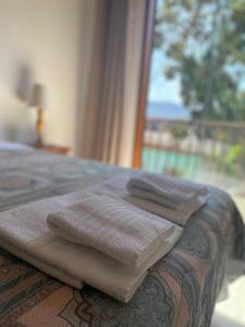 a bed with two towels on it with a window at Sobrado Torre in Tiradentes