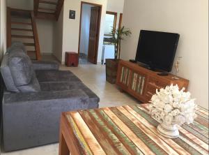 a living room with a couch and a tv at Sobrado Torre in Tiradentes