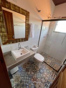 a bathroom with a sink and a toilet and a mirror at Sobrado Torre in Tiradentes