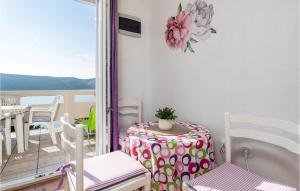 a room with a table and chairs and a balcony at Gorgeous Apartment In Stara Novalja With Kitchenette in Stara Novalja